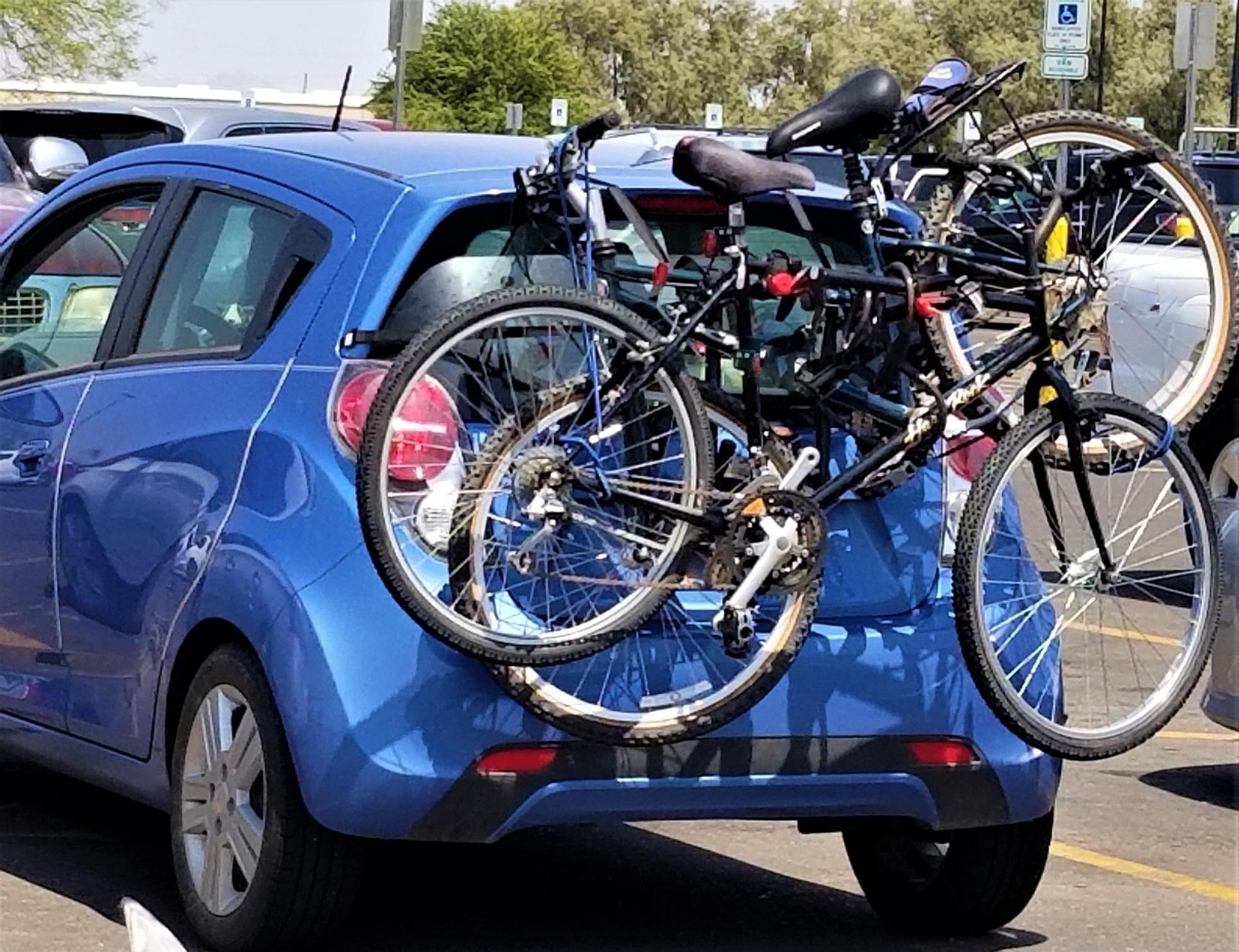 A car driving on a highway with a bike rack.