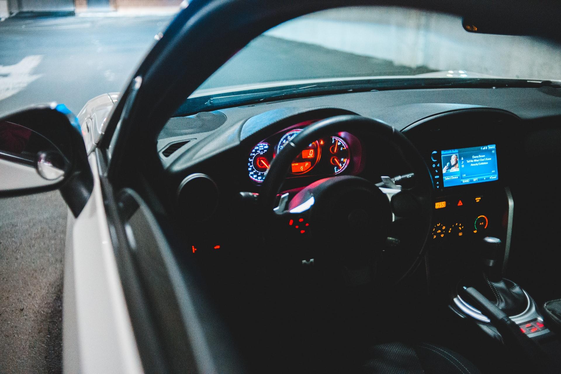 A view inside the driver’s side window of a parked autonomous car.