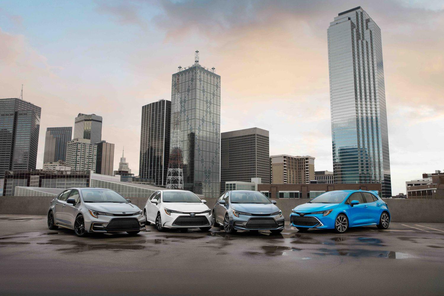 four Toyota Corollas in front of city buildings 