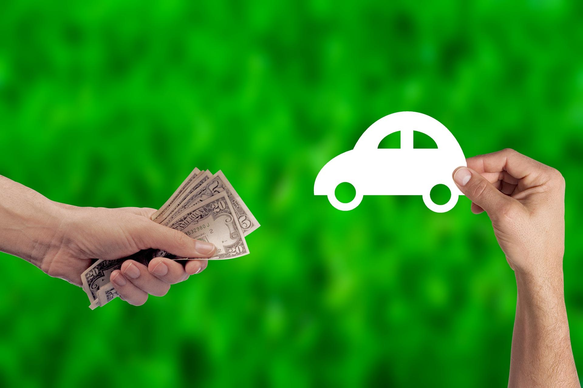 person holding out money by a cutout of a car in front of a green background 