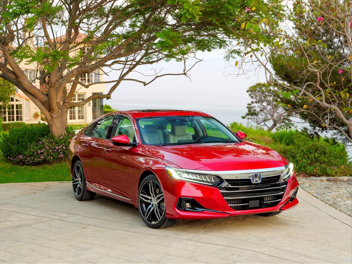 A red 2022 Honda Accord Hybrid parked outside by trees