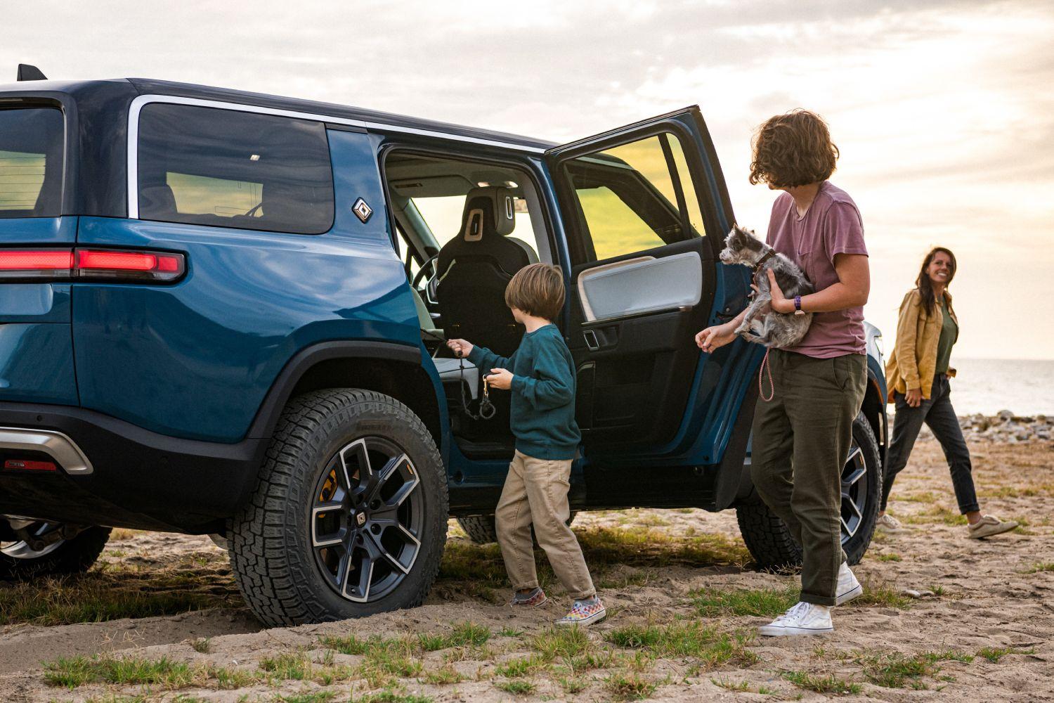 A family getting out of a Rivian R1S electric SUV.