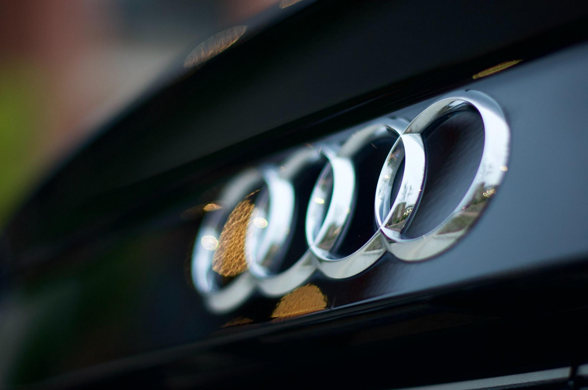 An close-up shot of the Audi logo on the front grille of a car.