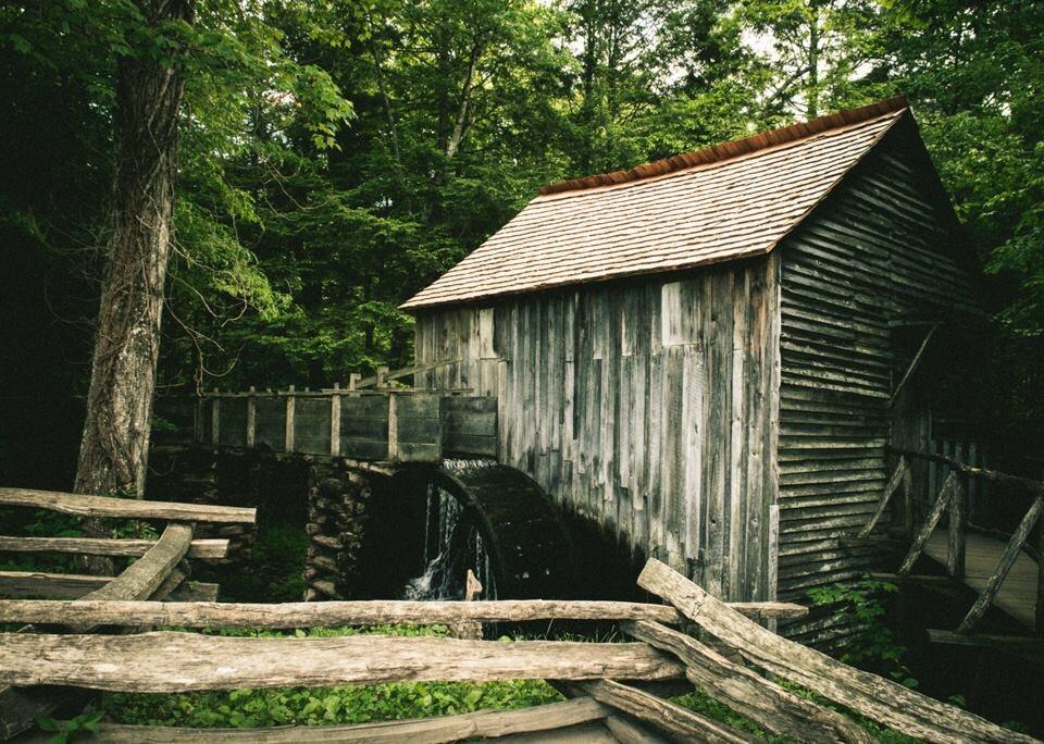 View of an old grist mill surrounded by woods.
