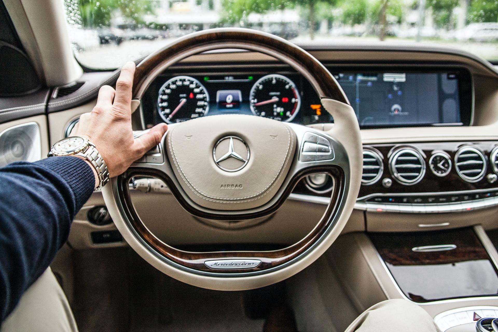 Tan Mercedes dash and wheel with driver